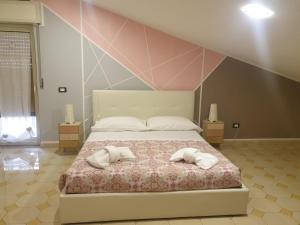 um quarto com uma cama com duas almofadas em Dimoramuri B&B em Catânia