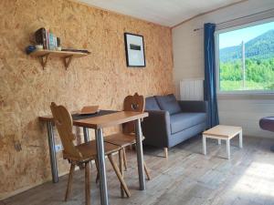 sala de estar con mesa y sofá en Chalet Notcimick, en Raon-sur-Plaine