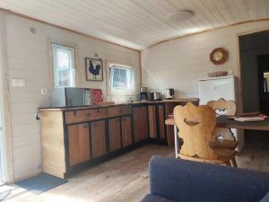 a kitchen with wooden cabinets and a table and a refrigerator at Chalet Notcimick in Raon-sur-Plaine