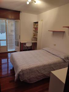 um quarto com uma cama, uma secretária e uma cadeira em Piso a pie de playa em Vilagarcía de Arousa