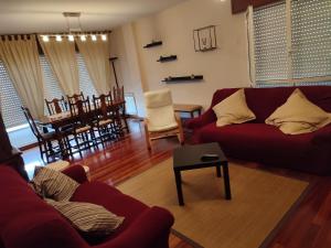 uma sala de estar com um sofá vermelho e uma mesa em Piso a pie de playa em Vilagarcía de Arousa