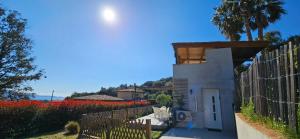 une maison blanche avec une clôture et des fleurs dans l'établissement Mini villa T2 climatisée, vue mer, cosy & moderne, à Olmeto