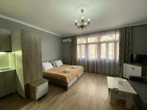 een slaapkamer met een bed en een woonkamer bij Guest House On Europe Square in Batoemi