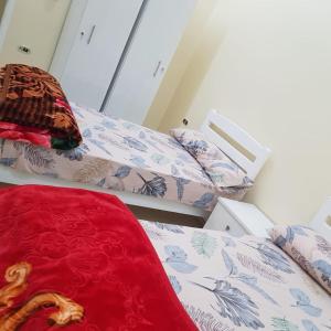 een kamer met drie bedden en een rode loper bij Sweet Home- No Egyptian in Hurghada