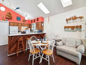 Una cocina y una sala de estar con mesa y sillas. en Bermuda Bungalow, en Galveston