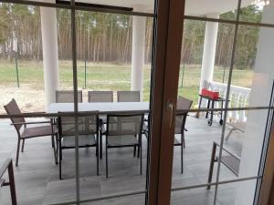 a screened porch with a table and chairs at New holiday home in Nowe Warpno for 10 people in Nowe Warpno
