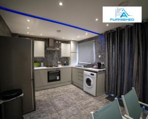 een keuken met een wasmachine en droger. bij Insurance Stays by Furnished Accommodation Liverpool - Family Home in Liverpool