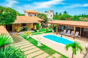 an image of a backyard with a swimming pool and a house at Casa em cond fechado em Barra de Santo Antonio AL in Barra de Santo Antônio