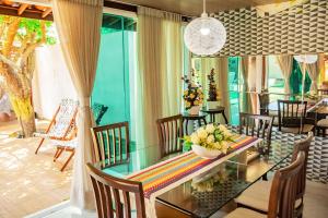 a dining room with a glass table and chairs at Casa em cond fechado em Barra de Santo Antonio AL in Barra de Santo Antônio
