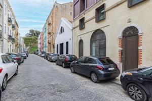 a row of cars parked on a cobblestone street at Hidden Pearl W/ Patio & Pool by LovelyStay in Lisbon