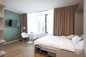 a bedroom with a bed and a desk and a window at Brera Serviced Apartments Munich West in Munich