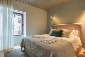 a bedroom with a bed with towels on it at Hidden Pearl W/ Patio & Pool by LovelyStay in Lisbon