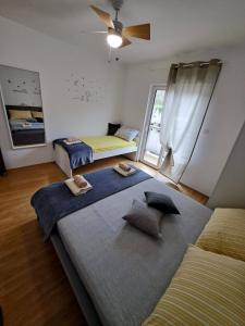 1 dormitorio con 2 camas y ventilador de techo en Apartman Ana en Rab