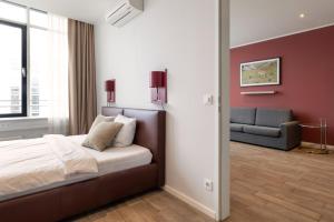 a bedroom with a bed and a couch at Brera Serviced Apartments Munich West in Munich