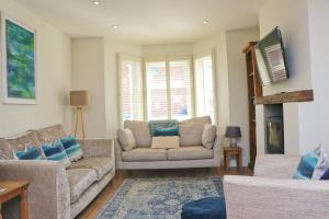 a living room with two couches and a fireplace at Padstow townhouse, close to harbour in Padstow