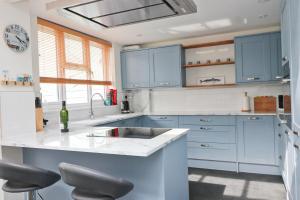 a kitchen with blue cabinets and a white counter top at Padstow townhouse, close to harbour in Padstow