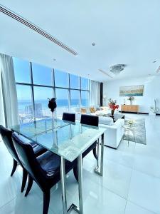 Skyline Apartments في المنامة: غرفة معيشة مع طاولة زجاجية وأريكة