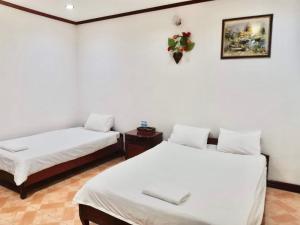 two beds in a room with white walls at Mina Hotel in Vientiane +6 photos