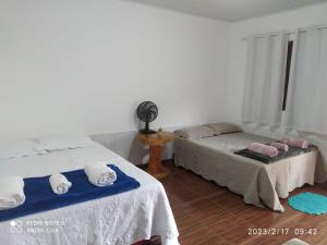 a bedroom with two beds and a fan at Encontro dos passaros in Ibicoara