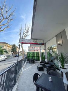 Hotel villa del bagnino في ريميني: مطعم على طاولات وكراسي على شرفة