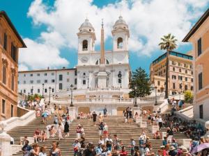 un gruppo di persone seduti sulle scale di fronte a un edificio di Vatican Apartment a Roma