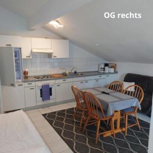 a kitchen with a table and chairs in a room at Ferienwohnungen Trapp-Mayer im ersten OG,Hunde willkommen in Bitzenhofen