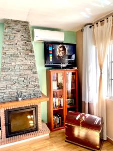 un soggiorno con camino e TV a schermo piatto di Cozy studio in benajarafe with chimney a Benajarafe