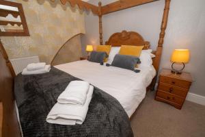 1 dormitorio con 1 cama con sábanas y almohadas blancas en Mont Millais, en Bridlington