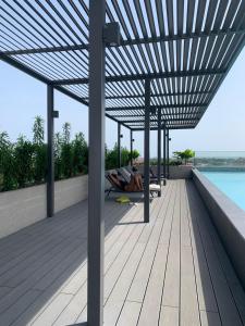 a person laying on a deck with a pergola at RT PROPERTIES @ THE LENNOX AIRPORT RESIDENTIAL in Accra