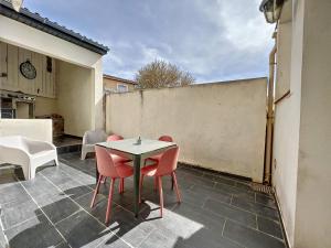eine Terrasse mit einem Tisch und Stühlen auf einem Innenhof in der Unterkunft Appart T3 LE PATIO - avec terrasse in Boujan-sur-Libron