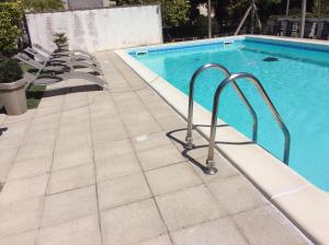 a swimming pool with a row of chairs next to it at Le Grillage a Poules in Gensac-la-Pallue