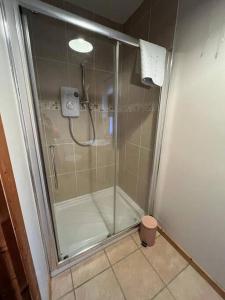 a shower with a glass door in a bathroom at The Shed. in Knockcloghrim