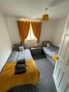 Nelson的住宿－Parklands Bungalow，一间卧室设有两张床和窗户。