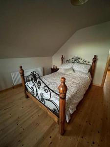 a bedroom with a large bed with a wooden floor at The Shed. in Knockcloghrim