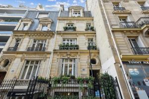 um edifício em Paris com vasos de plantas sobre ele em Le Paris Singulier em Paris
