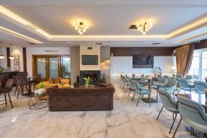 un vestíbulo de un hotel con mesas y sillas en Filippos Hotel en Halkidona