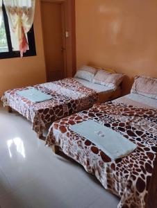 dwa łóżka siedzące obok siebie w pokoju w obiekcie AJjaa's Place w mieście Sagada