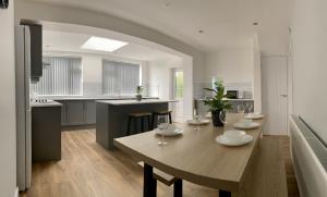 a kitchen with a table with wine glasses on it at Gateway Getaway in Horsforth Sleeps 7 in Leeds