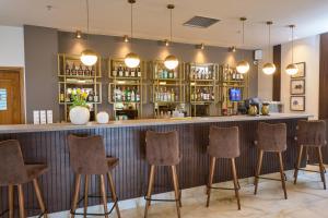 a bar with five stools in a room at Filippos Hotel in Halkidona