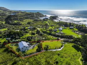 an aerial view of a house on a hill next to the ocean at THE BARN in Mahia