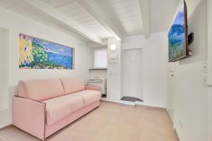 a living room with a pink couch and a painting at Via del Mare, Terre Marine in Riomaggiore