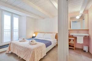 a white bedroom with a bed and a sink at Via del Mare, Terre Marine in Riomaggiore