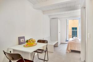 a white room with a table with a bowl of fruit on it at Via del Mare, Terre Marine in Riomaggiore +3 photos