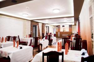 a dining room with white tables and chairs at Hotel Orion in Sosnowiec