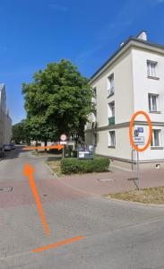 a street sign in front of a white building at Apartament Centrum Kościuszko in Suwałki