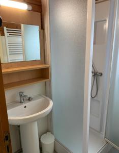 a bathroom with a sink and a shower with a mirror at Camping municipal de la Lande in Nexon