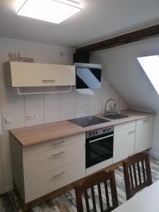 a small kitchen with a stove and a sink at Ferienwohnung IV Sarrebriese in Bottmersdorf +20 photos