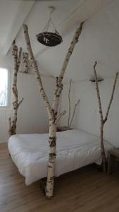 une chambre avec un lit doté de branches d'arbres dans l'établissement Gîte Mémoire de cœur 14 pers, à Foucherans