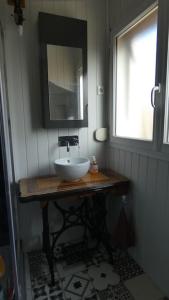 La salle de bains est pourvue d'un lavabo, d'un miroir et d'une fenêtre. dans l'établissement Gîte Mémoire de cœur 14 pers, à Foucherans