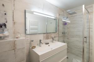 ein weißes Badezimmer mit einem Waschbecken und einem Spiegel in der Unterkunft Dom Jelenia - 1km de la plage in Cancale